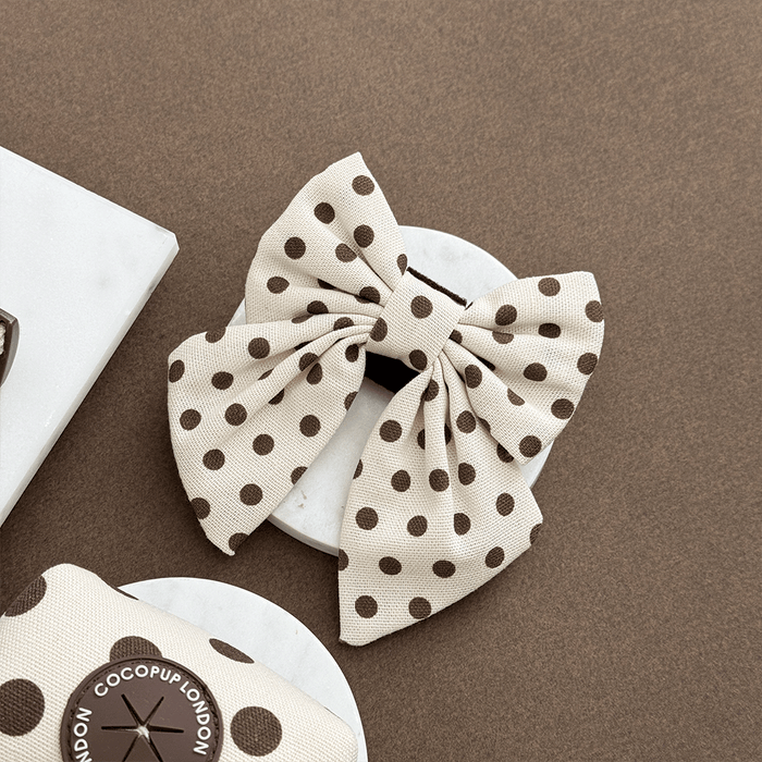 Polka dot sailor bow tie on a brown background with 'Cocopuff London' branding.