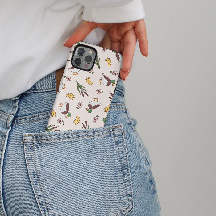 A Cocopup London Puddle Pup phone case being slipped into the back pocket of light blue jeans.