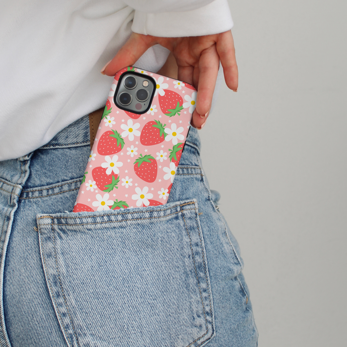 A hand slides a Cocopup London Pupberry Fields phone case with pink and berry print into blue jeans back pocket.