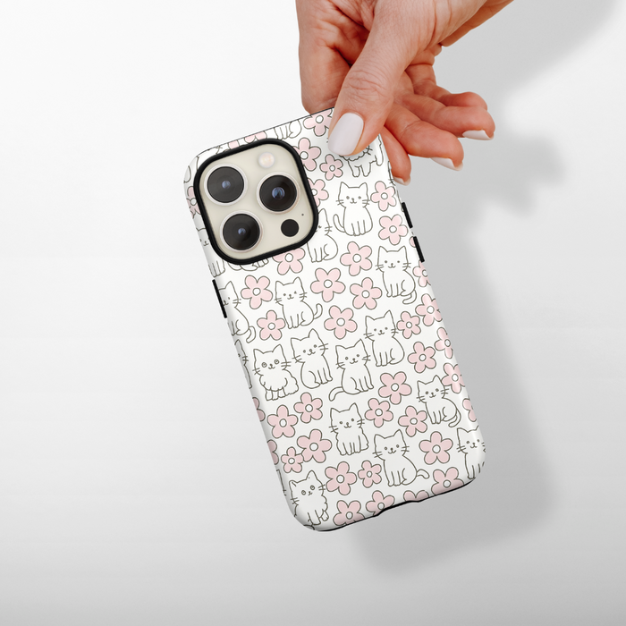Cocopup London Tough Phone Case with a pattern of cute cats and pink flowers, held in a hand.