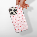 Hand holding a pink gingham Cocopup London Tough Phone Case with strawberries on the back.