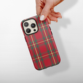 Hand holding a Cocopup London phone case with a red tartan plaid pattern.