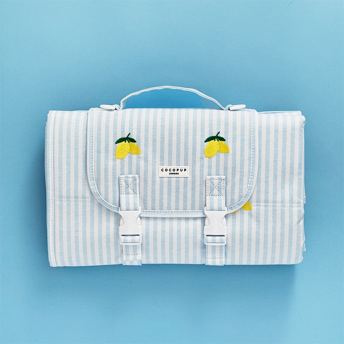 Cocopup London travel mat with blue and white stripes, lemon pattern, and a carrying handle.