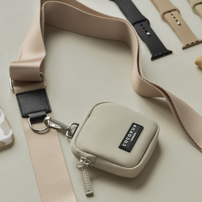 Caramel Latte Cocopup London treat pouch with wide strap and metal clip, next to smartwatch bands and a phone case.