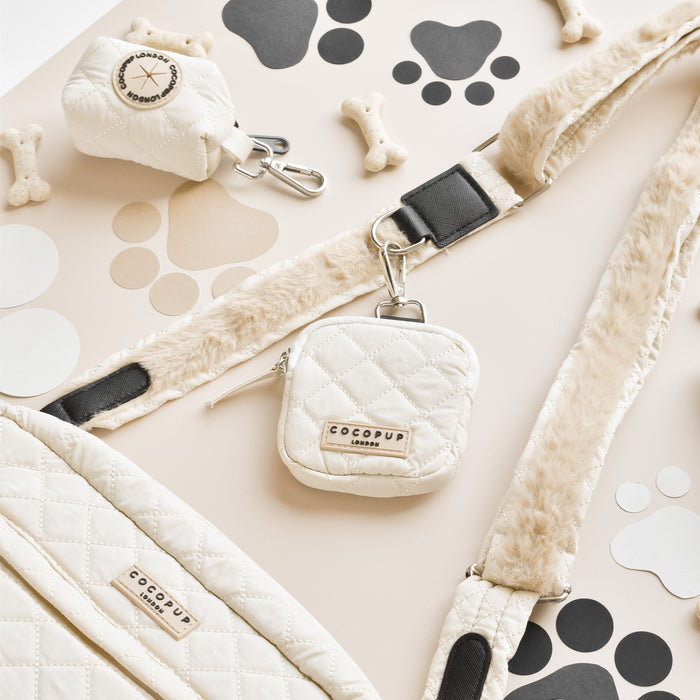 Cream quilted treat pouch with faux fur accents and paw print details on a neutral background.