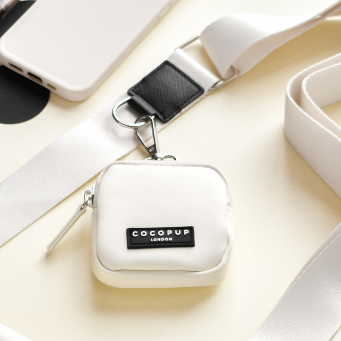 Oyster white Cocopup London treat pouch on a light surface, simple design with zip closure.