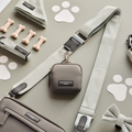 A flat lay photo features pet accessories, including a grey leash, waste bag holder, collar, and personal pouch from "Cocopup London." Also in the image are dog bone-shaped treats, a small bow tie, and paw print designs on a light green background with the stylish Tweed Bag Strap in Sage from Cocopup London – perfect for your dog's walking bag.