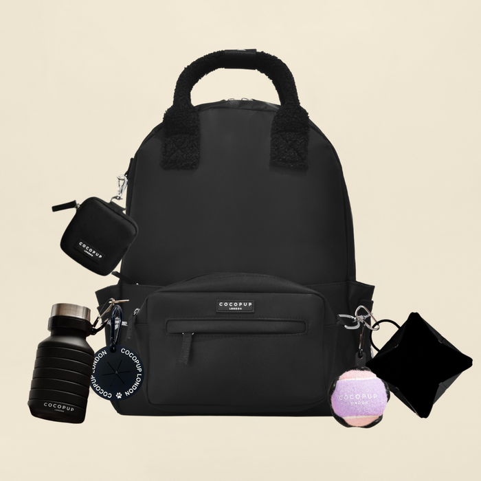 Black Cocopup London rucksack bundle with matching keychains, water bottle, and pouches arranged together.
