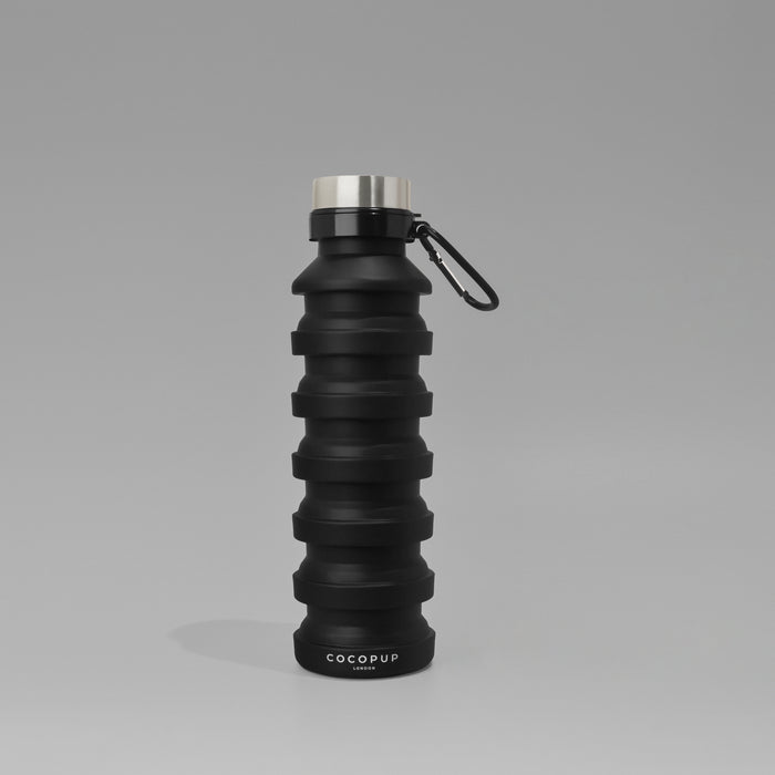Black collapsible water bottle from Cocopup London next to The Ultimate Rucksack Bundle.