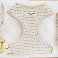 Cream and gold tweed dog harness with adjustable neck, laid flat on a white background.