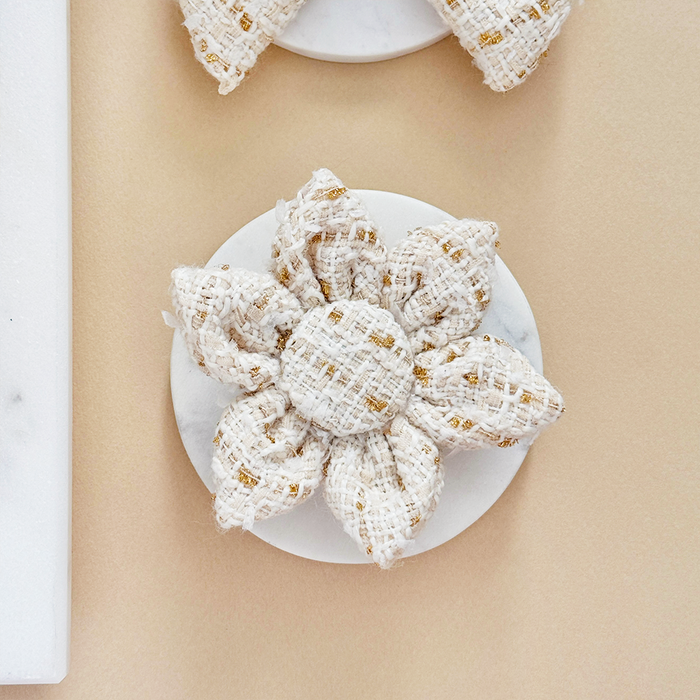Vanilla textured tweed five-petal collar flower for dogs by Cocopup London on a white marble surface.