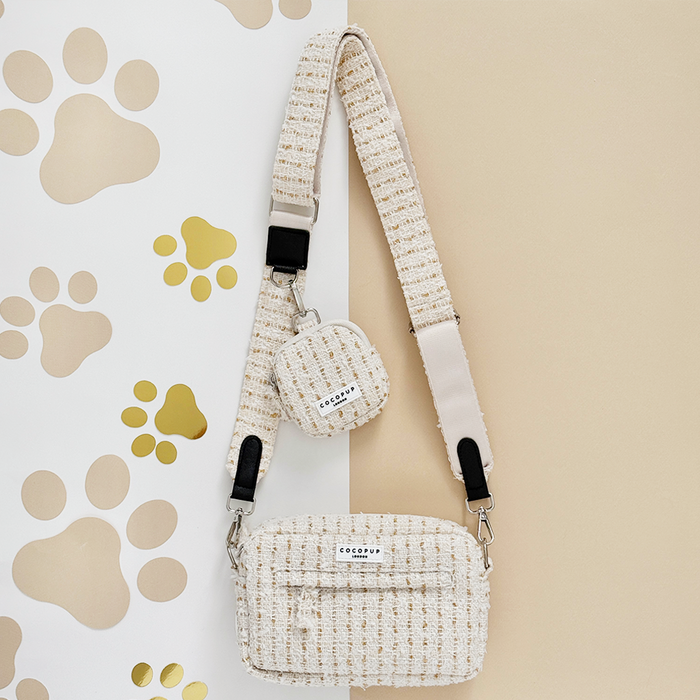 Vanilla textured tweed dog walking bag bundle with treat pouch and white straps, displayed on a paw print background.