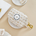 Vanilla textured tweed poop bag holder by Cocopup London on a white tray.