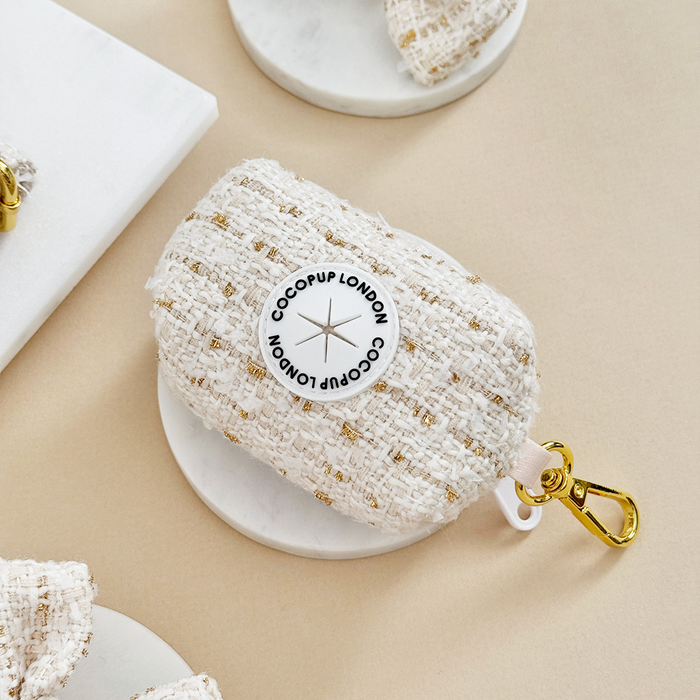 Vanilla textured tweed poop bag holder by Cocopup London on a white tray.