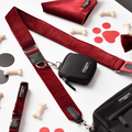 Berry red velvet bag strap by Cocopup London with black dog walking bag, collar, bone and paw print details.