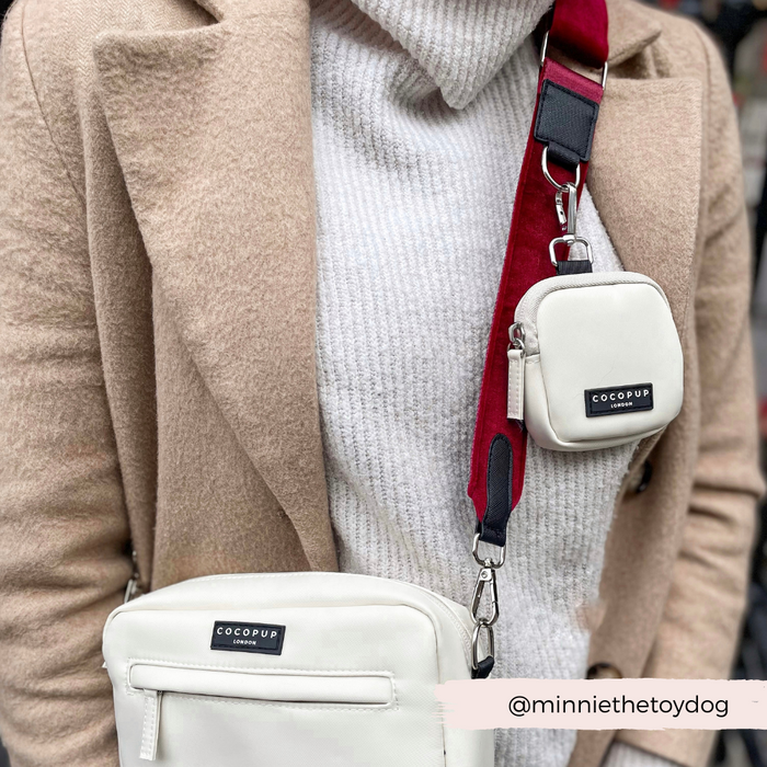 woman wearing white dog walking bag with red velvet strap