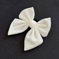 White velvet sailor bow tie by Cocopup London against a black background.