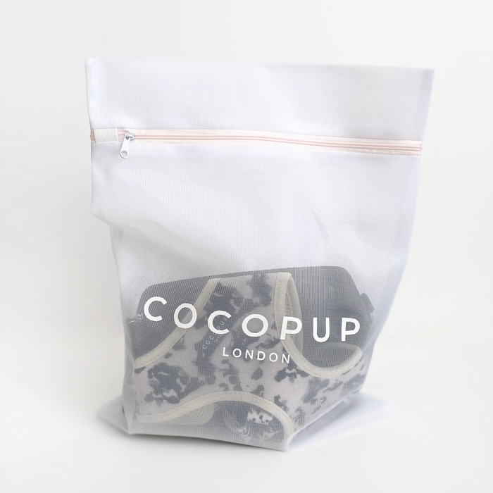 White mesh Cocopup London laundry bag with zipper closure.
