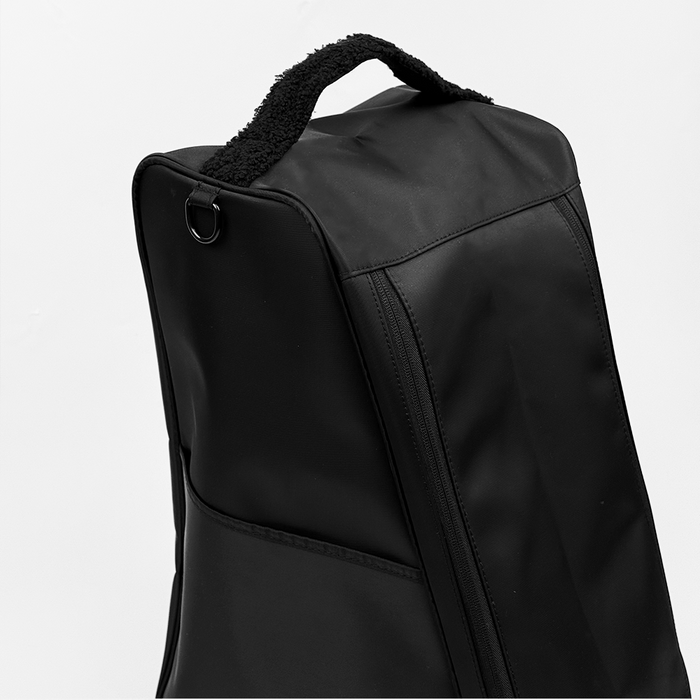 Black Cocopup London Welly Boot Bag with zippered compartment and soft furry handle on a white background.